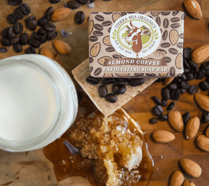 Almond-Coffee-Exfoliating-Soap-Bar-from-above-with-milk-honey-and-coffe-beans-on-wooden-board